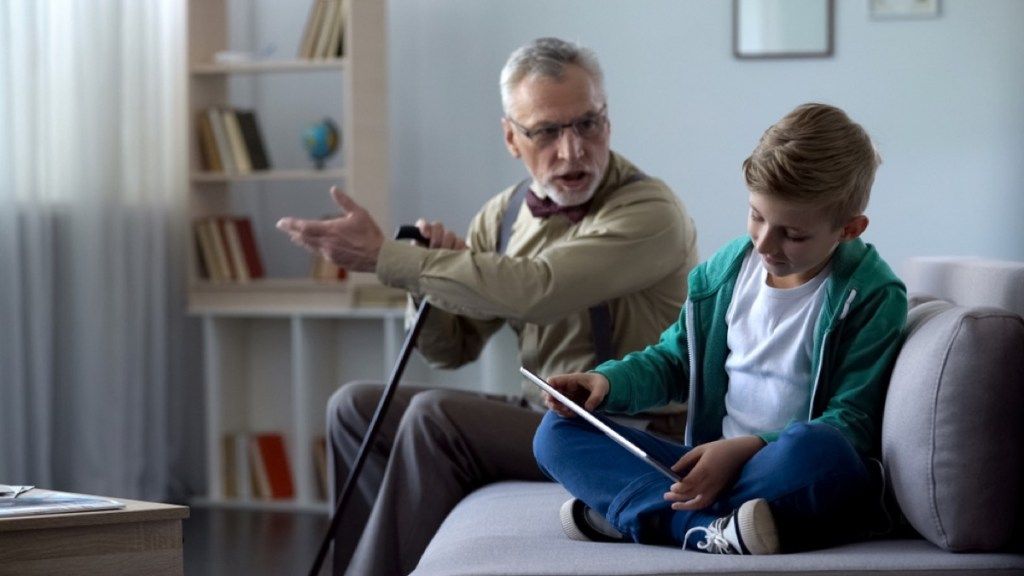 Hombre mayor gritando a un niño jugando en la tableta, cosas que molestan a los abuelos