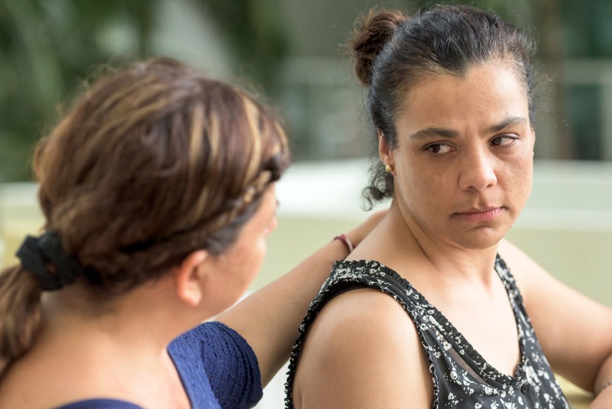 Triste mujer latina siendo consolada por un amigo o hermana