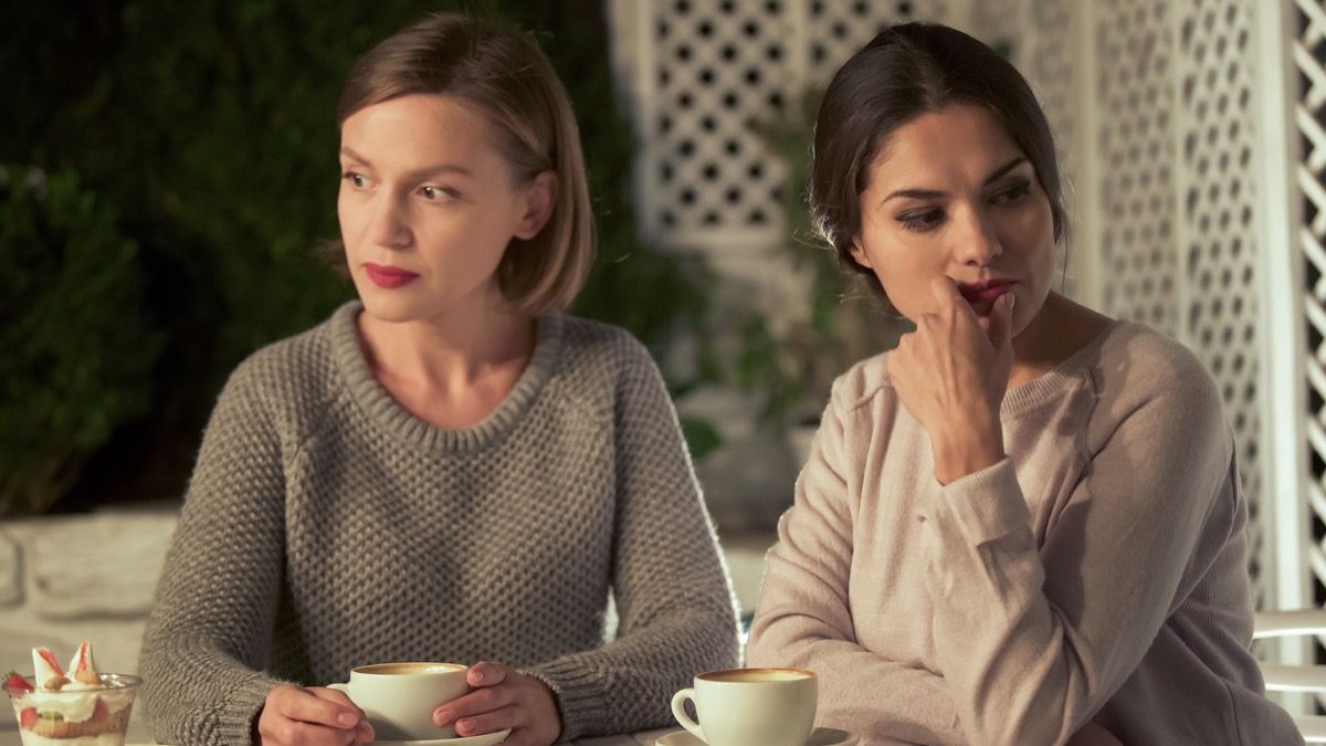 Dwie zdenerwowane kobiety mają nieporozumienia przy kawie