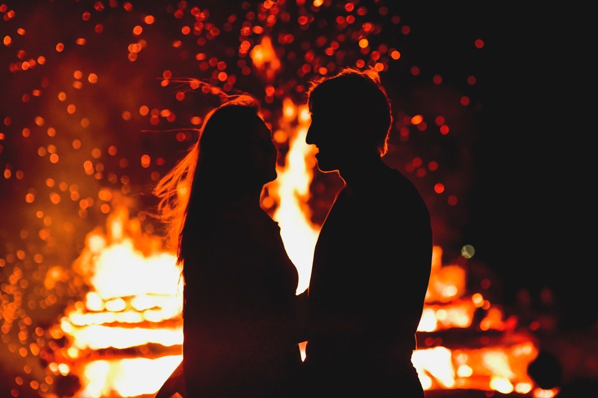 Paar vor dem Feuer, verrückteste Dinge, die Bräute und Bräutigame jemals bei Hochzeiten getan haben