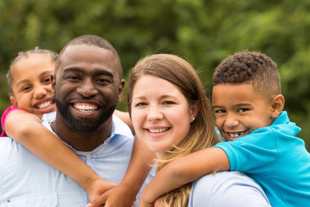 casal interracial com dois filhos ao ar livre, mau conselho aos pais