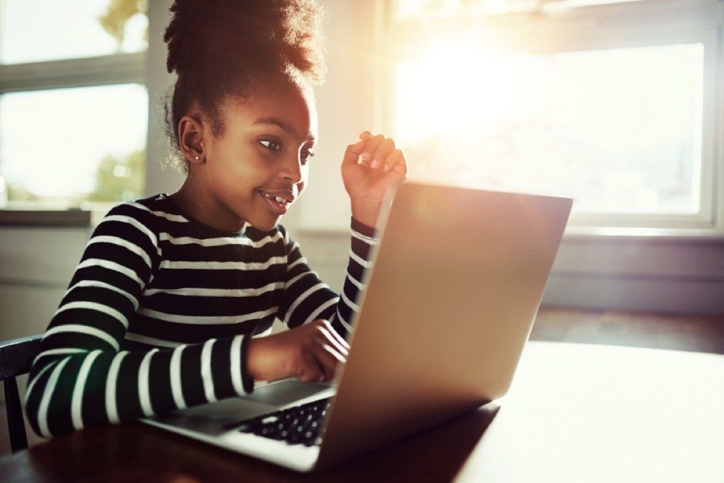 момиче, използващо лаптоп, умения, които родителите трябва да преподават на децата