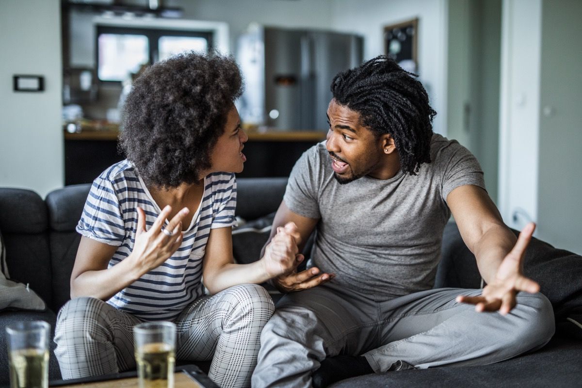 nuori musta nainen ja nuori musta mies väittelevät keskenään sohvalla