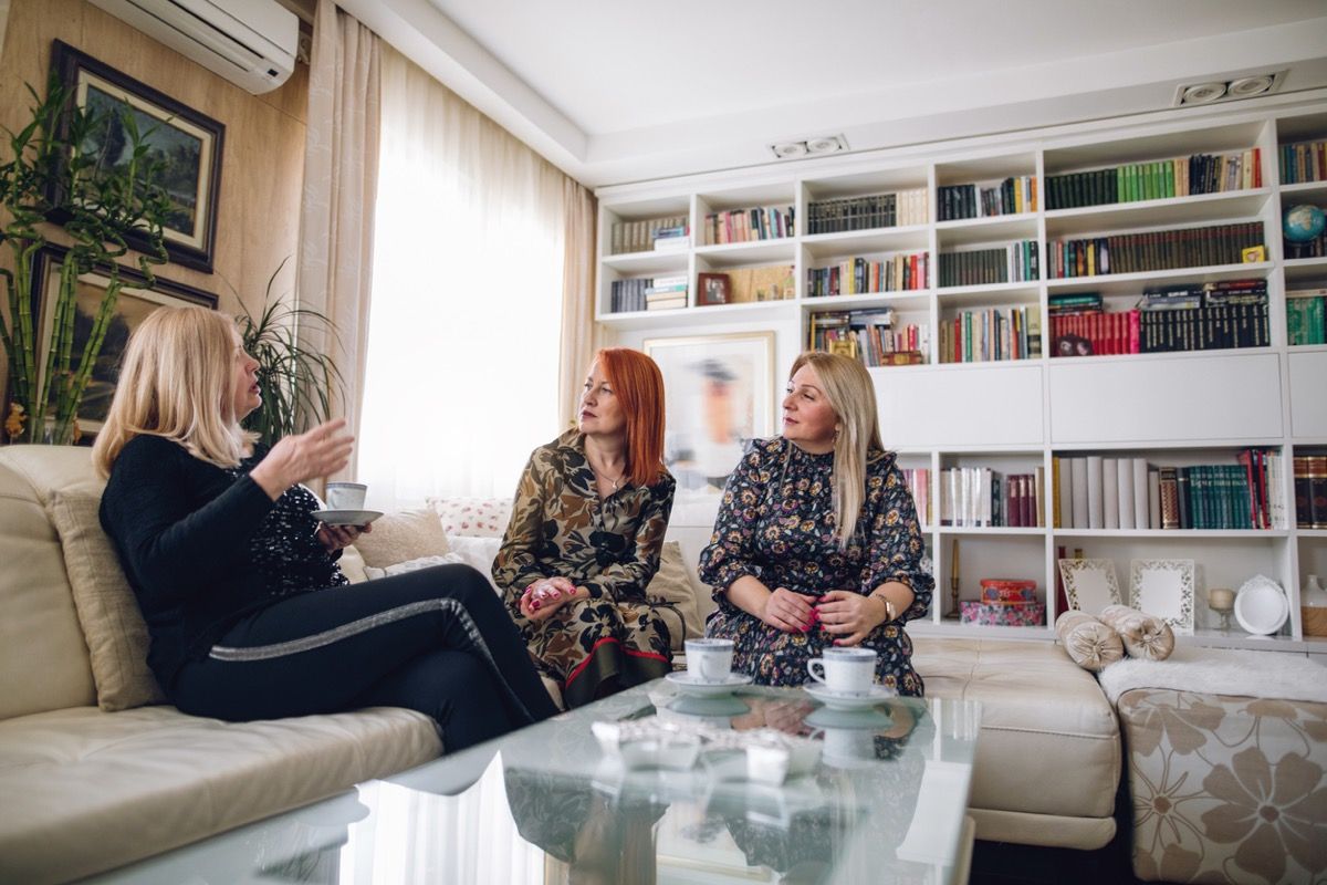 tres mujeres maduras disfrutando de su tiempo juntas en casa, tomando café.