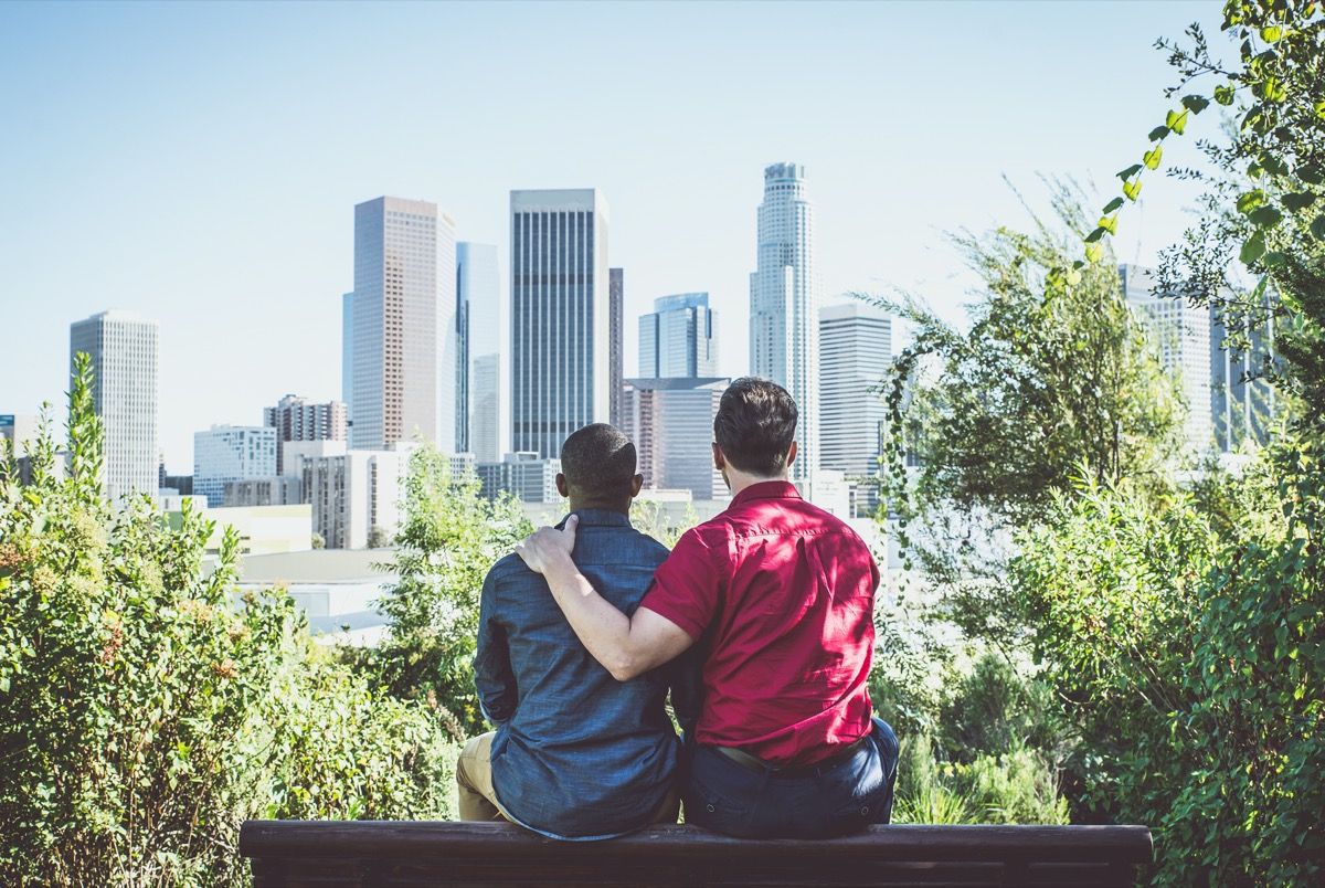 Noor homopaar vaatab linna siluetti.