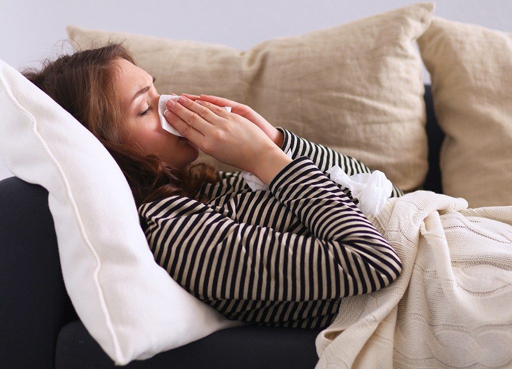 dona esternudant al sofà: estar soltera