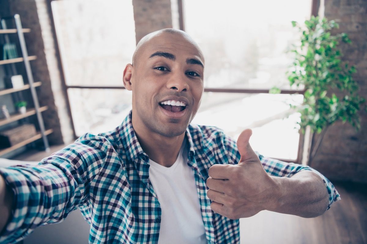 giovane uomo di colore prendendo un selfie e dando un pollice in alto