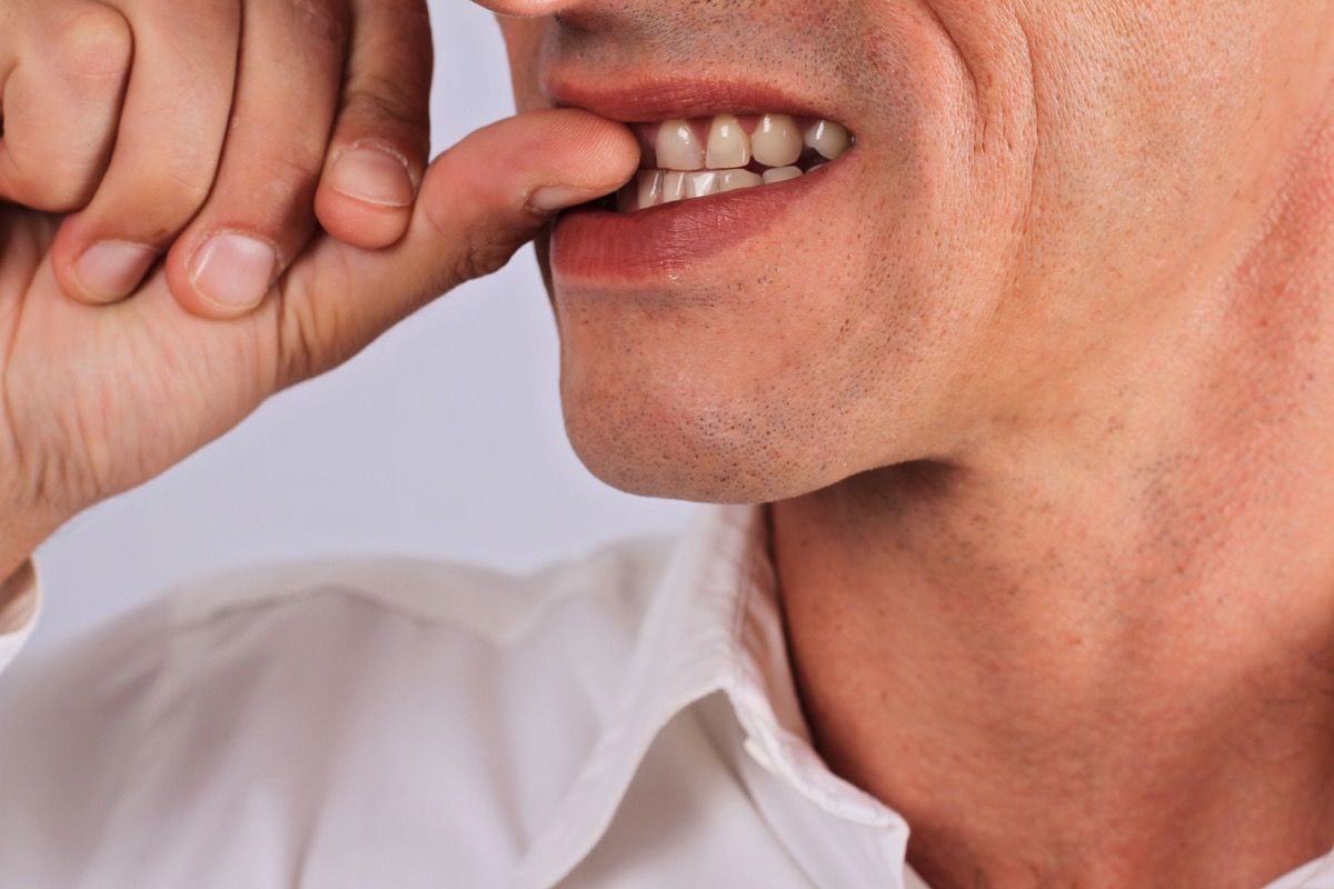 Närviline mees, kes hammustab oma küüsi lapsepõlve harjumusi, mis mõjutavad tervist