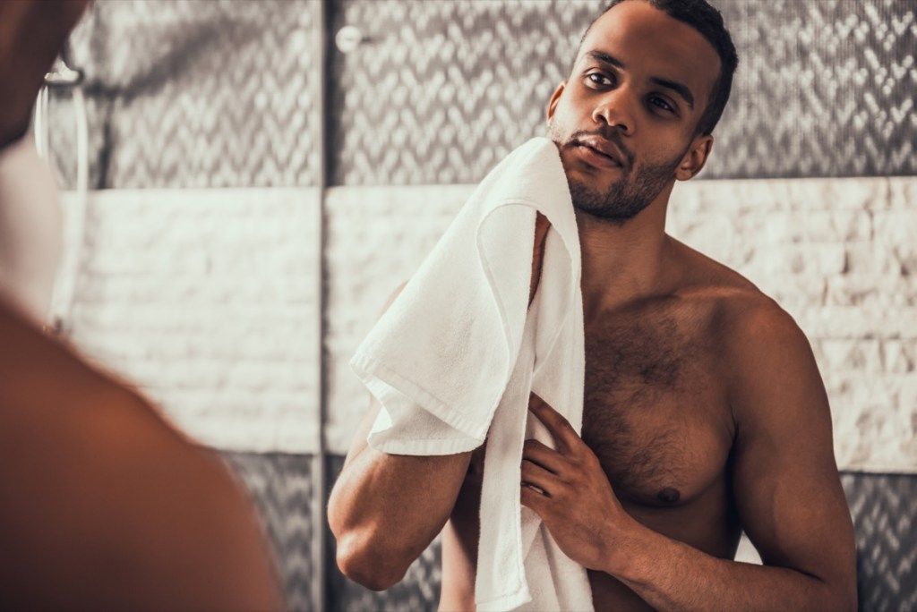 Мужчина без рубашки, держащий полотенце, смотрит в зеркало, отношения белой лжи