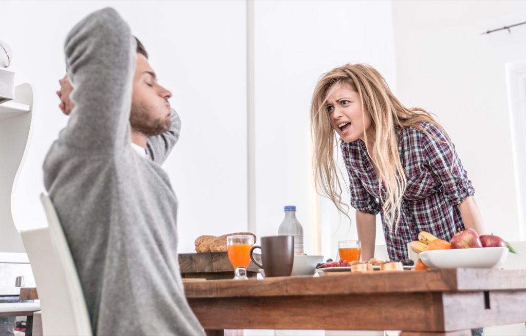 Kvinne som roper på kjæresten sin på kjøkkenet, tegn på juks
