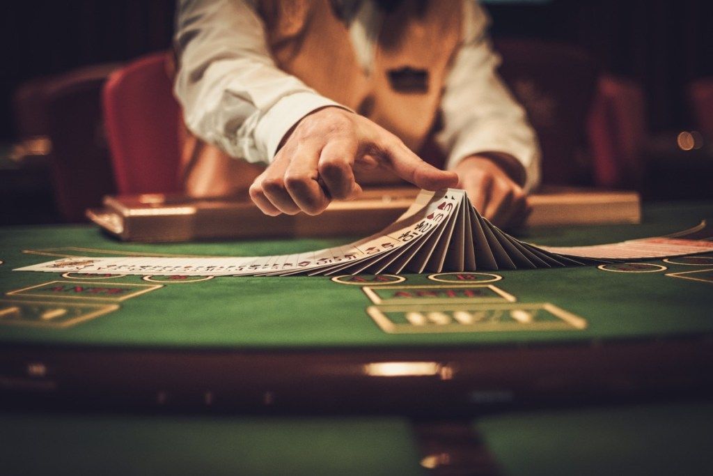 Croupier dietro al tavolo da gioco in un casinò con alti tassi di divorzio