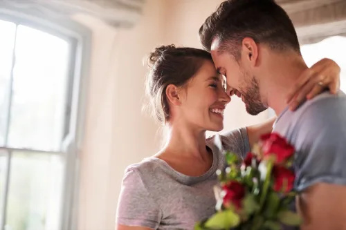   αποσπάσματα σχέσης - χαμογελαστό ζευγάρι ερωτευμένο με κόκκινα τριαντάφυλλα