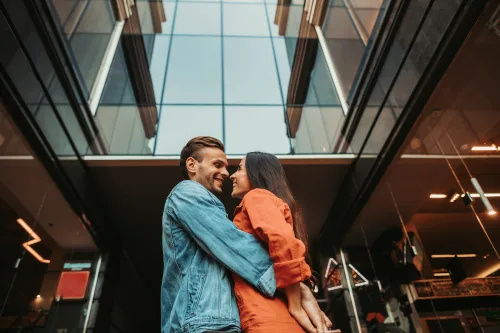   homme et femme s'embrassant devant le bâtiment