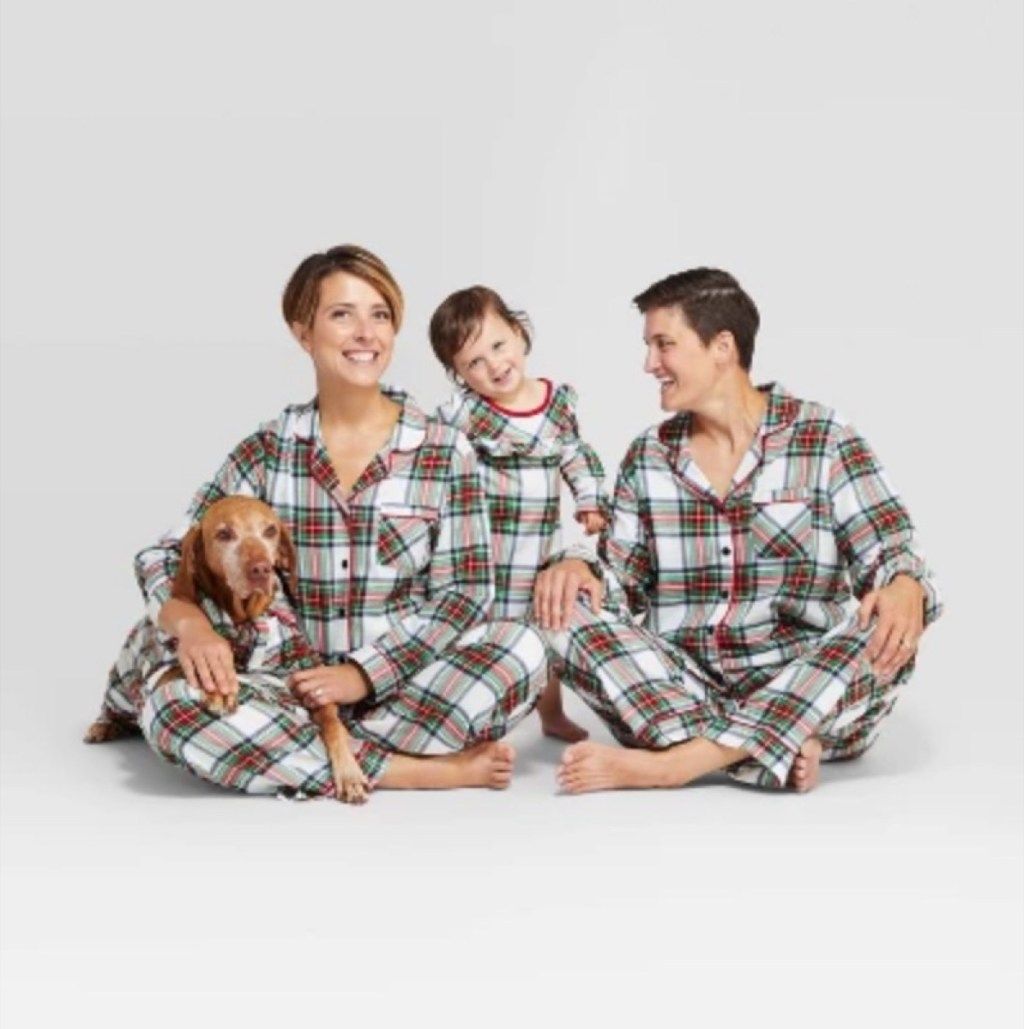 kaksi äitiä tyttären ja koiran kanssa ruudullisessa pyjamassa