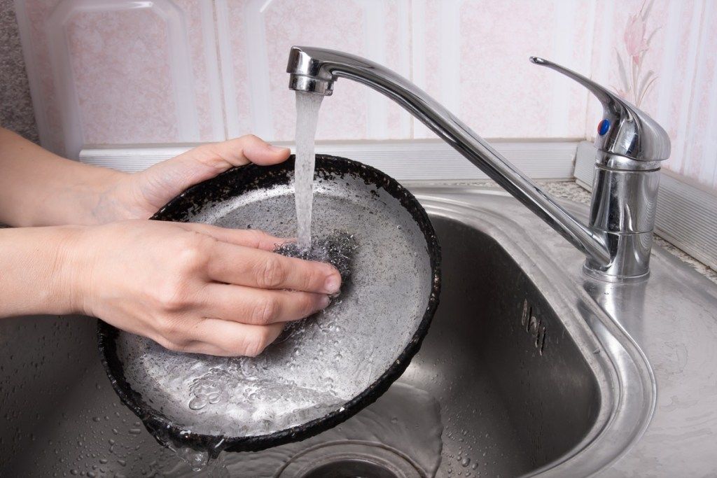 weiße Handwaschpfanne mit Stahlwolle