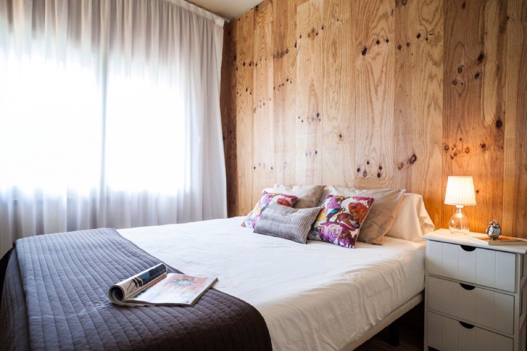बिस्तर के पीछे लकड़ी की दीवारें