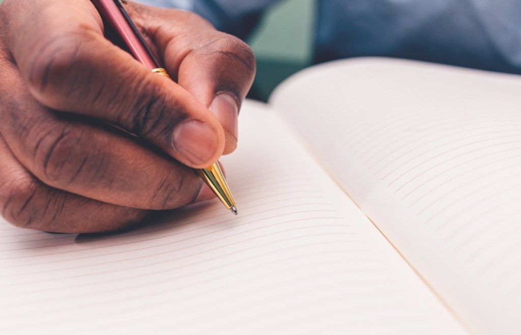 Hombre negro escribiendo en un cuaderno