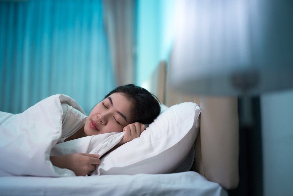 Ázsiai nő alszik az ágyban