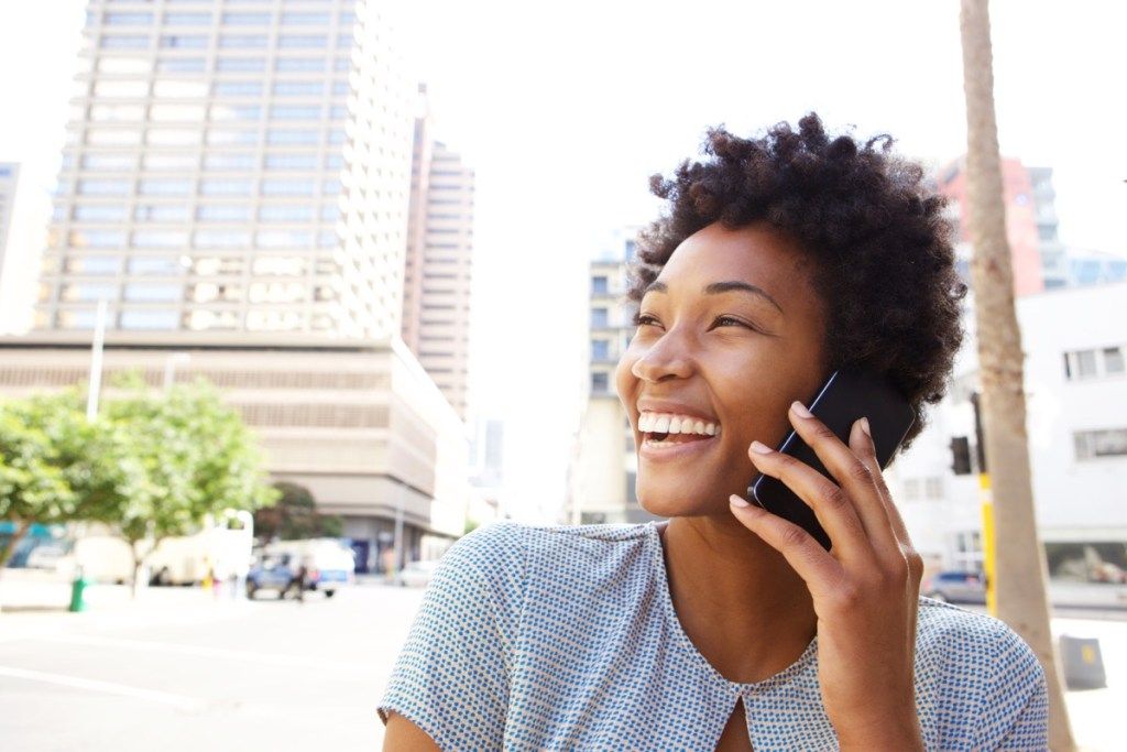 그녀의 휴대 전화에 친구를 호출하는 흑인 여성