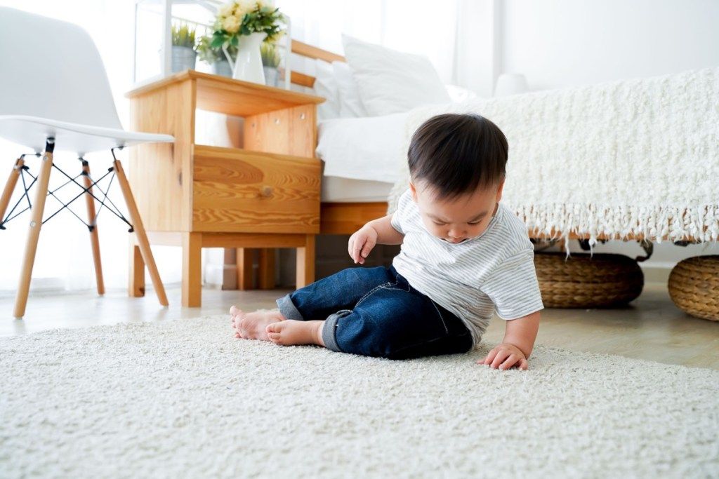 jauns zēns uz maisa paklāja