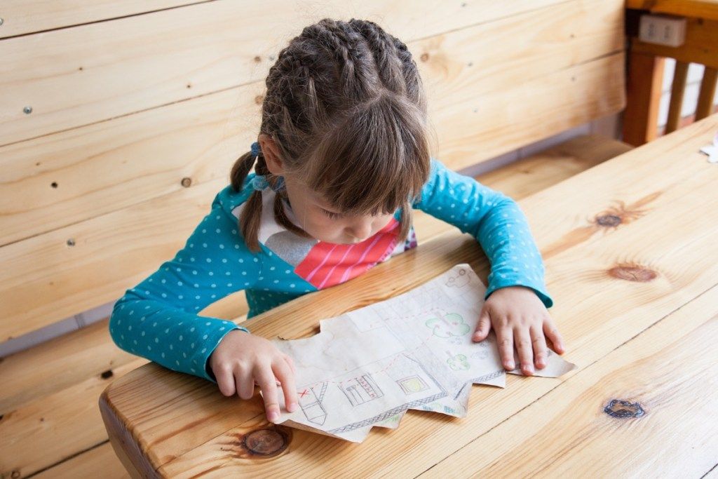 mała dziewczynka patrząc na mapę skarbów