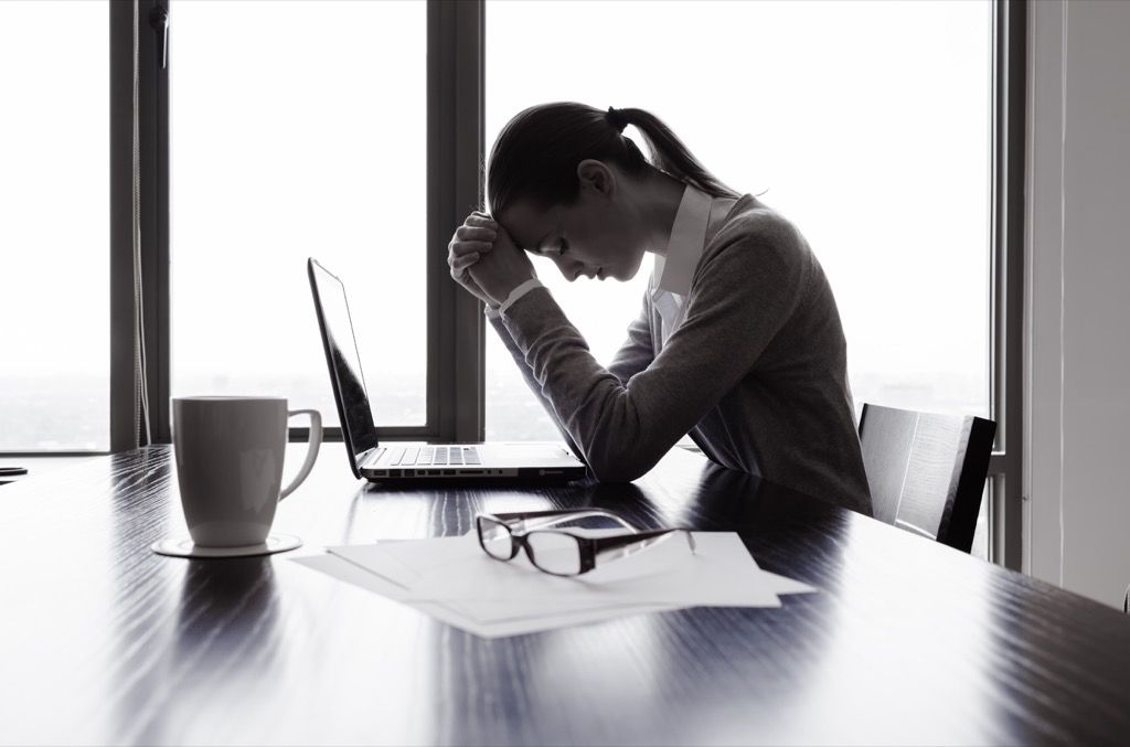 stresset kvinne ved et skrivebord og følte seg skyldig