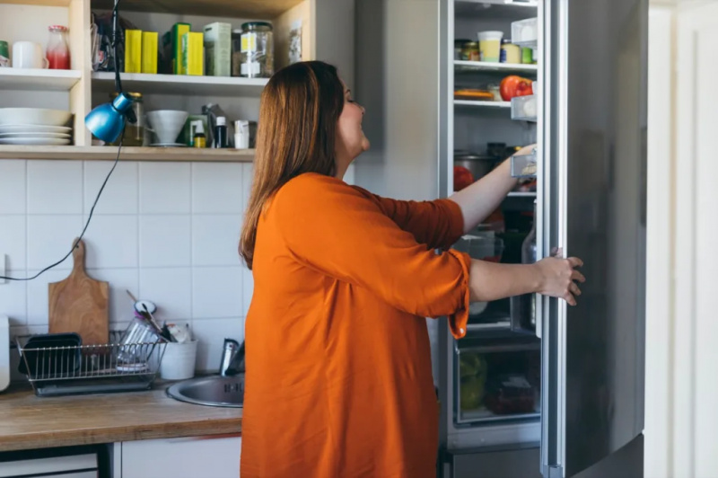   אישה לוקחת משהו מהמקרר להכין ארוחת בוקר במטבח