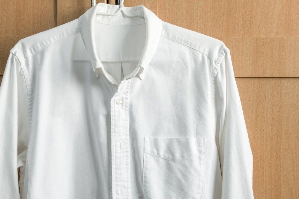 camisa blanca con botones colgando
