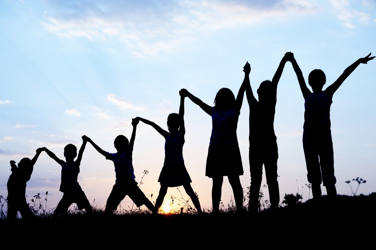 7 lasta käsi kädessä kentällä auringonlaskun siluetti