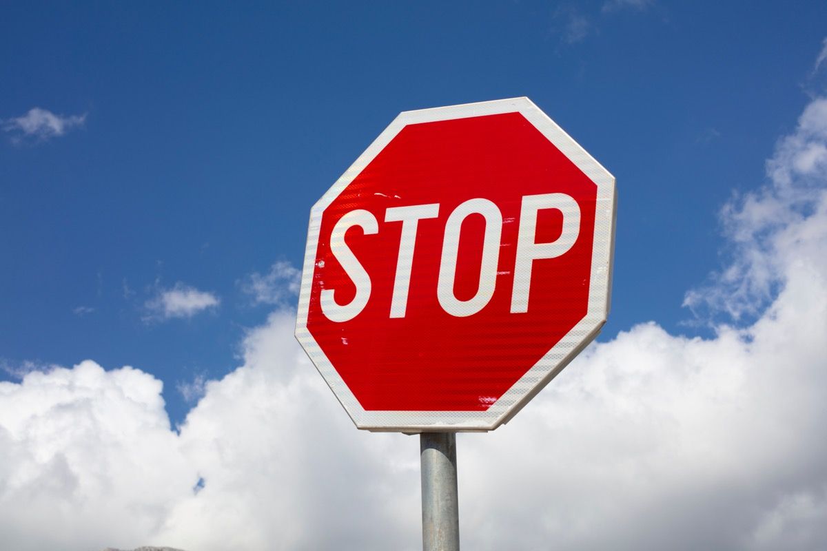 Stop-merkki sinistä taivasta vastaan ​​pilvillä