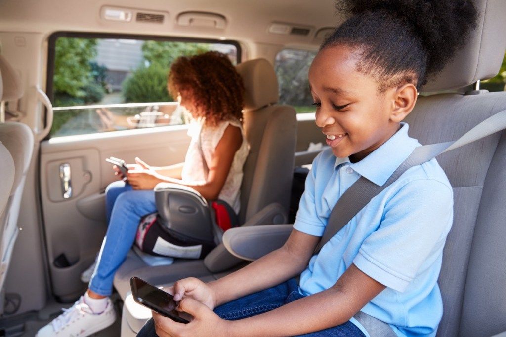 Nens que fan servir dispositius digitals al viatge en cotxe, pirates informàtics