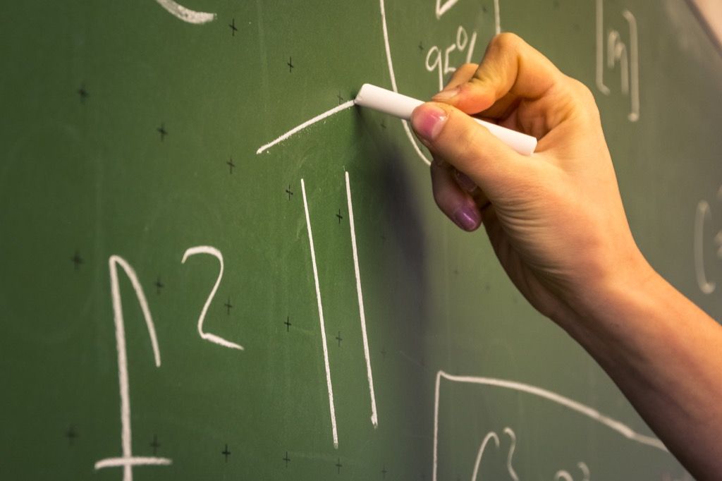 käsi, joka kirjoittaa 6. luokan matemaattiset yhtälöt liitutaululle {Tricky Math Questions}