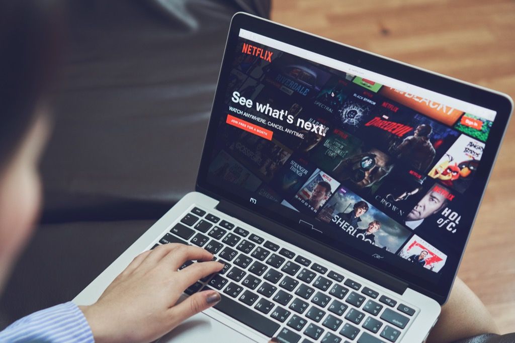 một người đàn ông đang xem những bộ phim hay nhất trên Netflix trên máy tính xách tay của mình