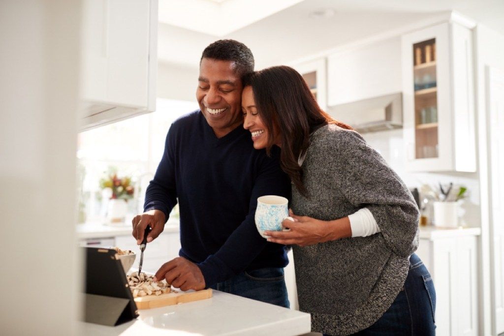 черна двойка на средна възраст, готвеща над печка, здравословни промени над 40