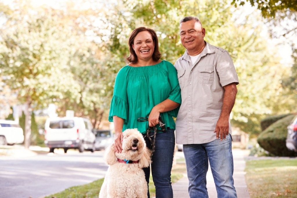 Латинская пара среднего возраста на улице с собакой