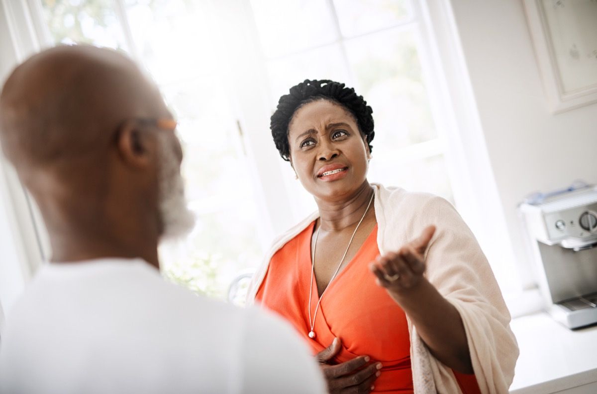 Mujer gesticula al marido en frustración durante una conversación seria