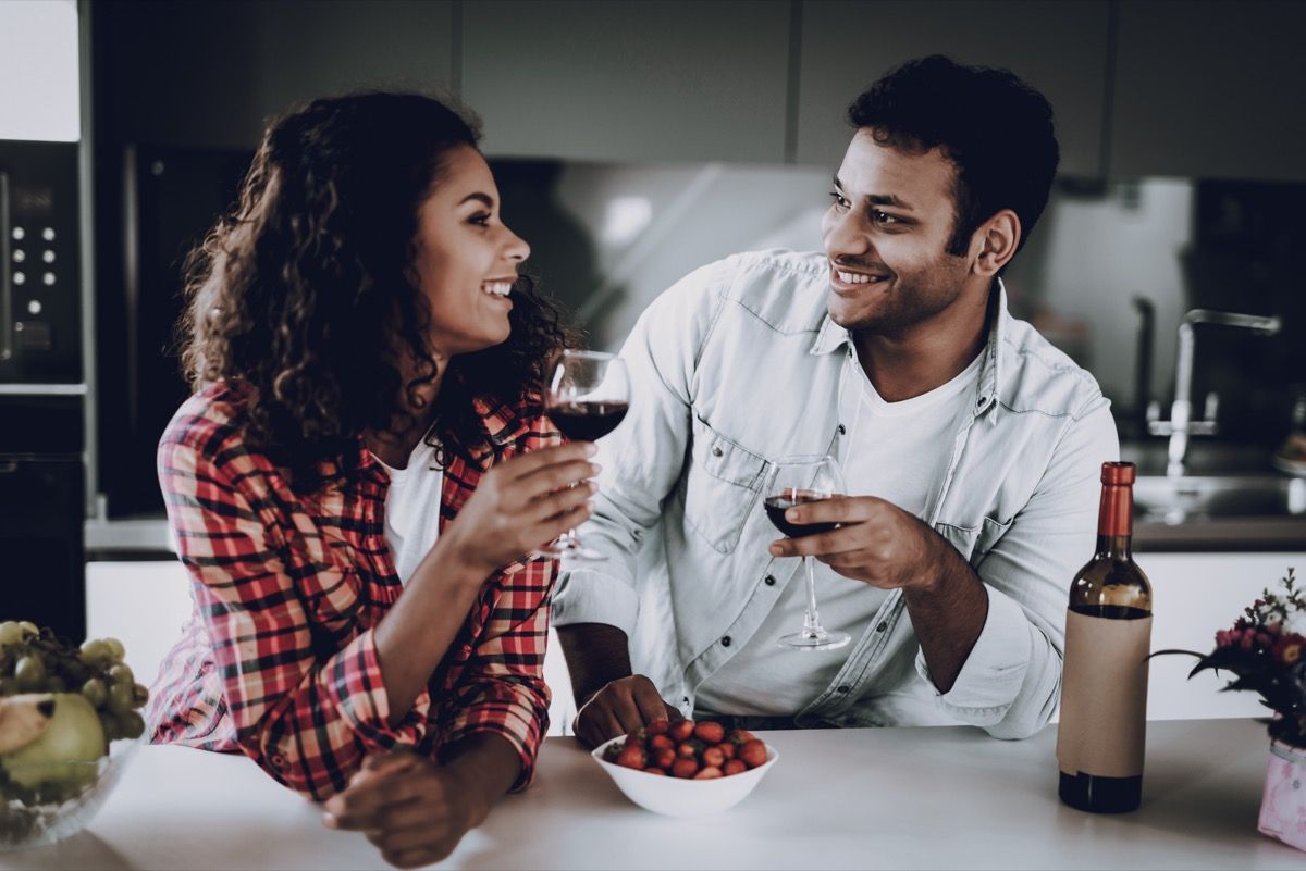 coppia che beve vino rosso in cucina durante il giorno