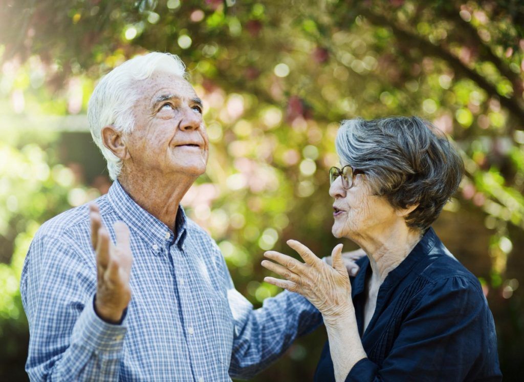 Starejši moški razočarano zavije v oči, ko mu partner jezno gestikulira.