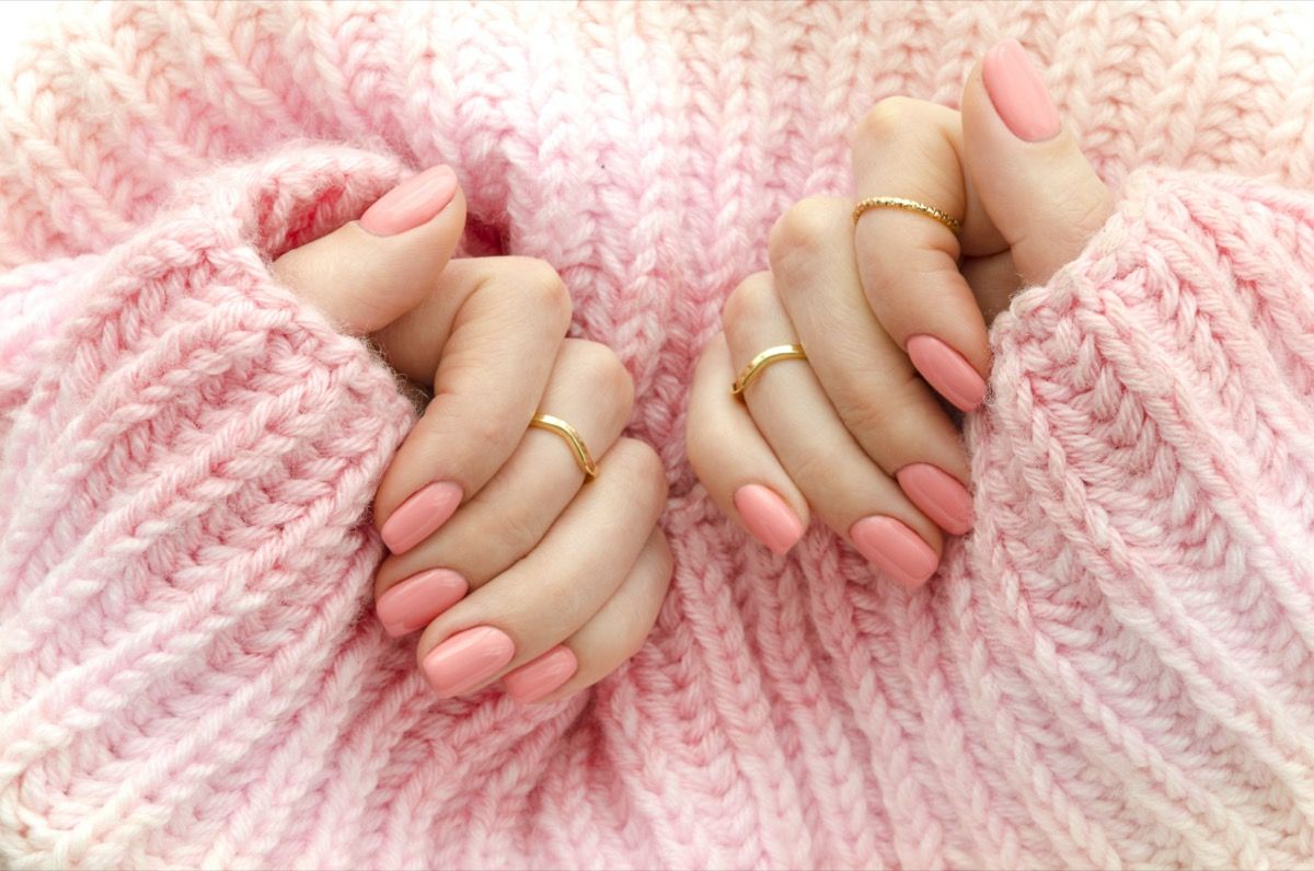 Kädet vaaleanpunaisella manikyyrillä