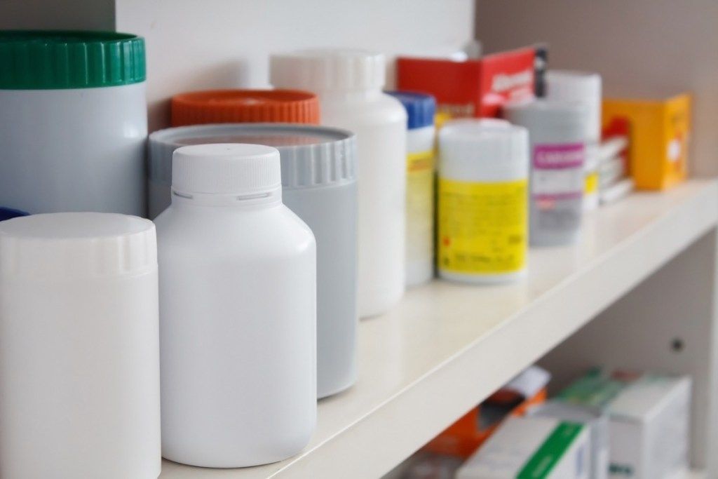 gomila neobilježenih bočica s lijekovima u ormariću s lijekovima