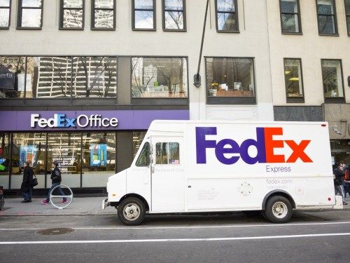 New York, New York, ZDA - 13. marec 2013: Parkiran tovornjak FedEx Express sredi Manhattna pred trgovino v pisarni Fedex popoldan. FedEx je ena vodilnih storitev dostave paketov, ki ponuja veliko različnih možnosti dostave. Trgovine Fedex Office delujejo kot ladijski skladišče, kot tudi skladišča pisarniškega materiala in storitev. Ljudje so vidni na ulici. [url = / my_lightbox_contents.php? lightboxID = 3623142] Kliknite tukaj za več [/ url] newyorških slik in video posnetkov.