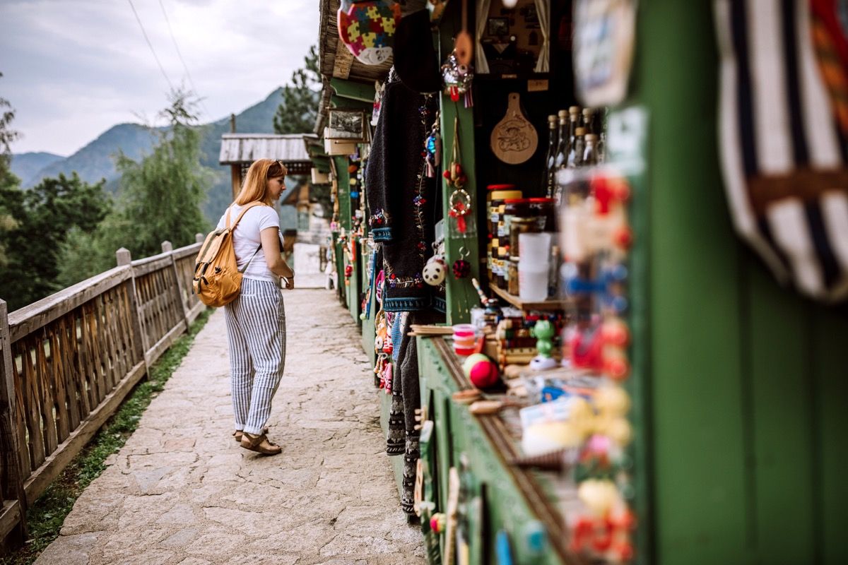 นักท่องเที่ยวหญิงกำลังมองหาของฝากที่ตลาดริมทางในวันหยุดฤดูร้อน