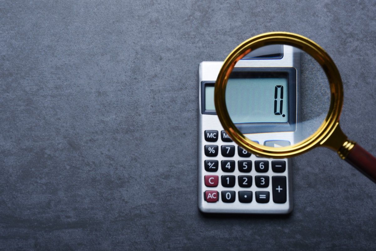 Finansielle konsepter, en kalkulator som viser null med forstørrelsesglass