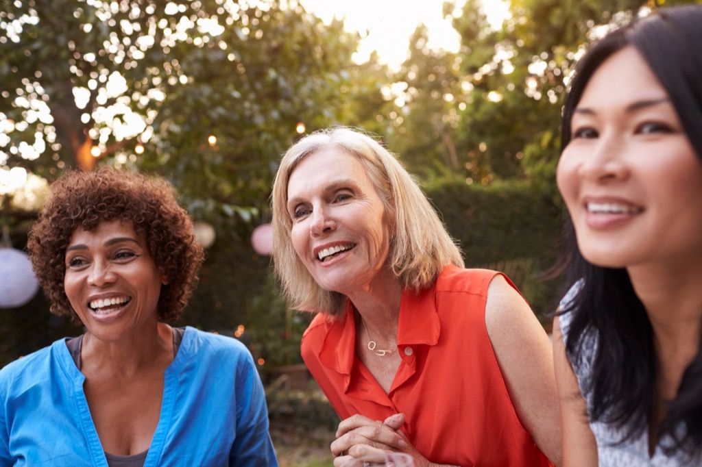 kolme naista hymyilee ulkona, miten saada ystäviä 40 jälkeen