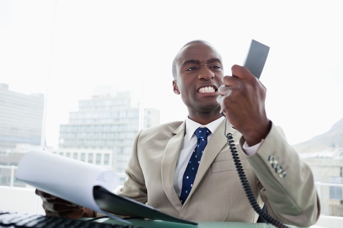 Zły czarny biznesmen na telefonie, czego nie można mówić obsłudze klienta