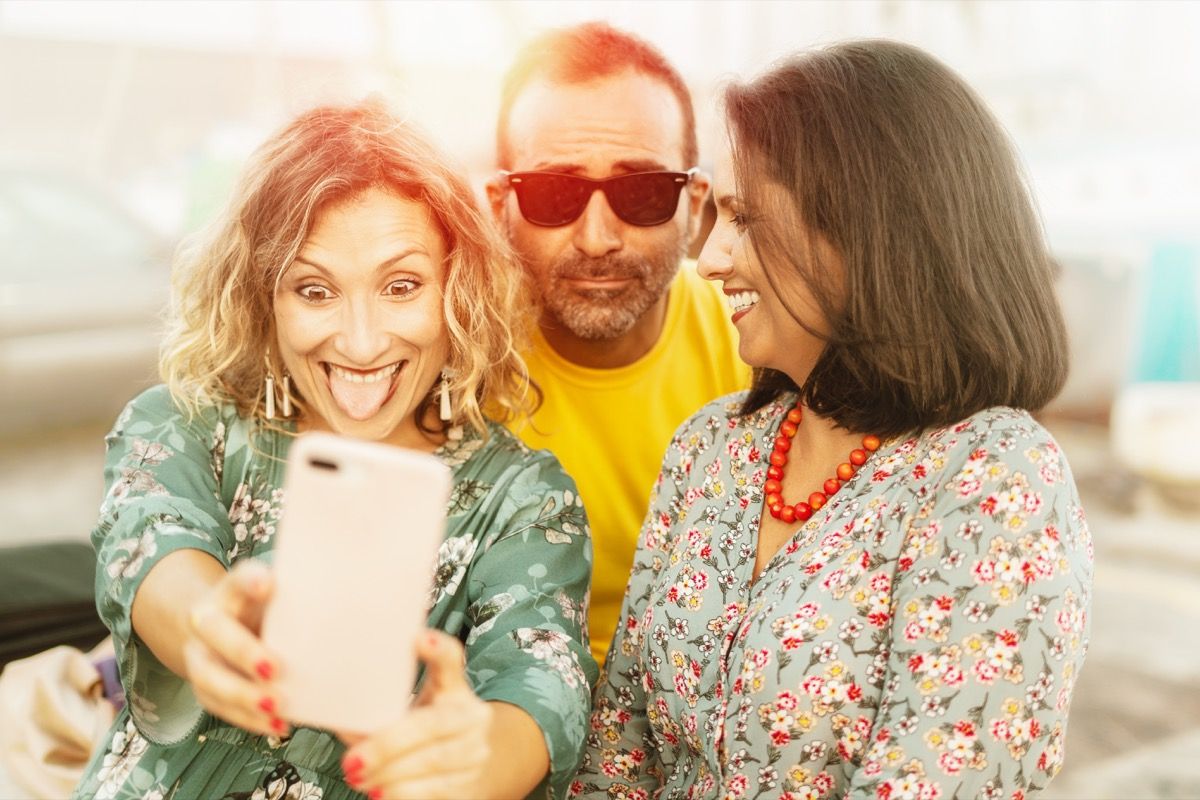 Sredovječni prijatelji koji se glupo zabavljaju snimajući selfieje telefonom