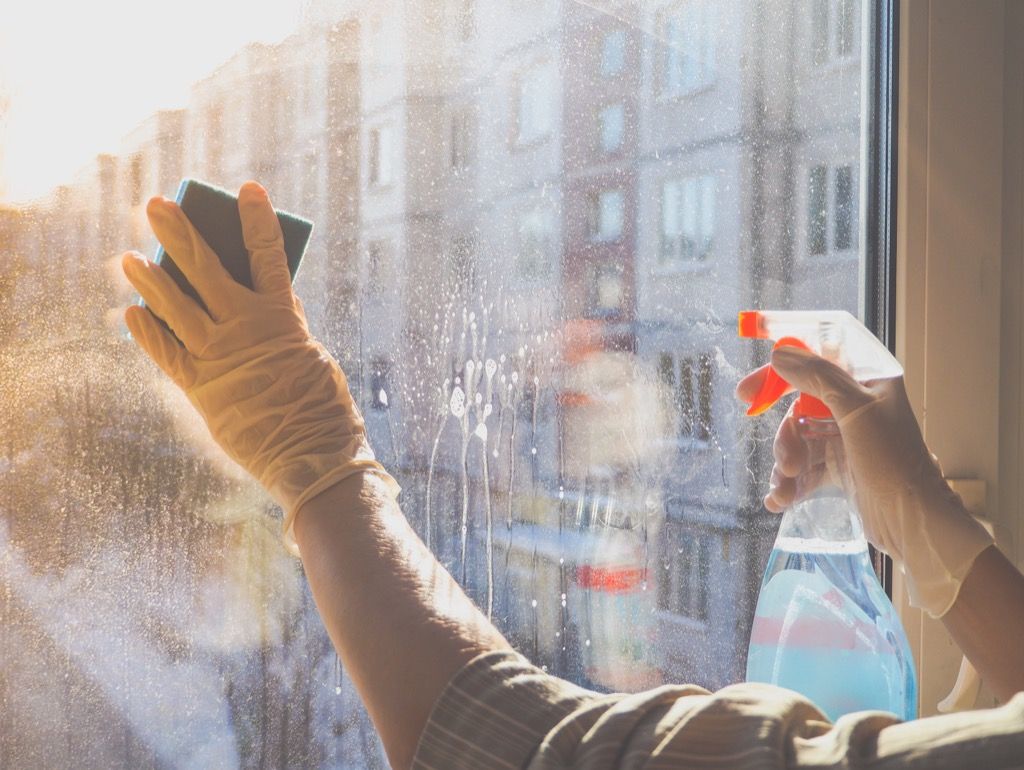 oseba, ki čisti stekleno okno, enostavni nasveti za dom