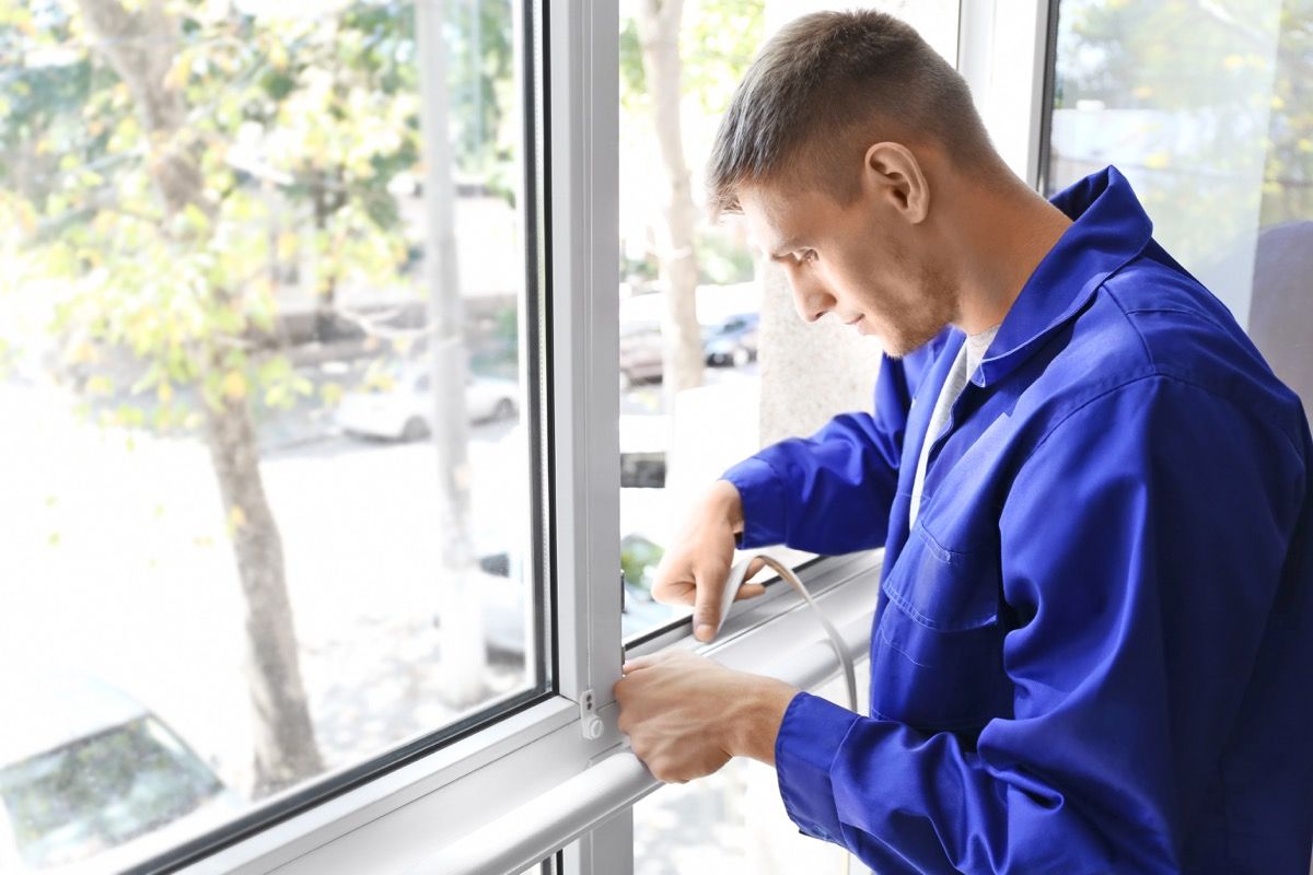 treballador que segella les coses de la finestra a casa seva atraient plagues