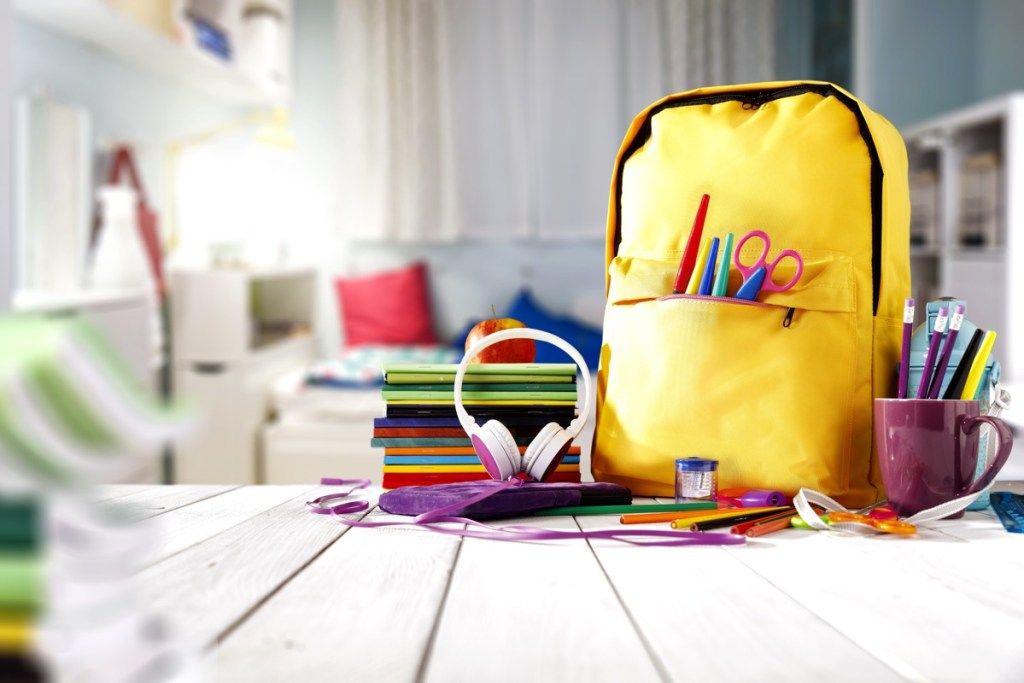 Mesa de material escolar e uma mochila