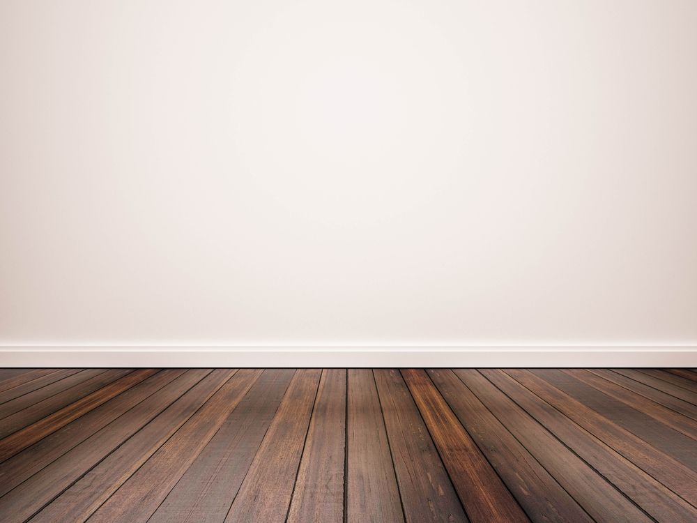 सफेद दीवार के खिलाफ दृढ़ लकड़ी का फर्श